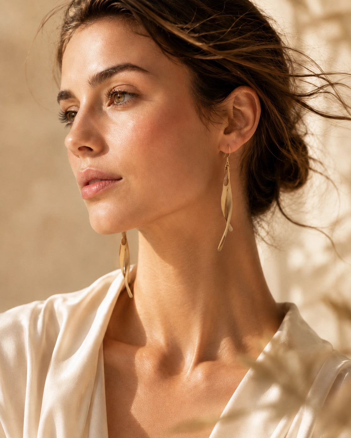 Model wearing Bamboura handwoven bamboo earrings in warm natural light