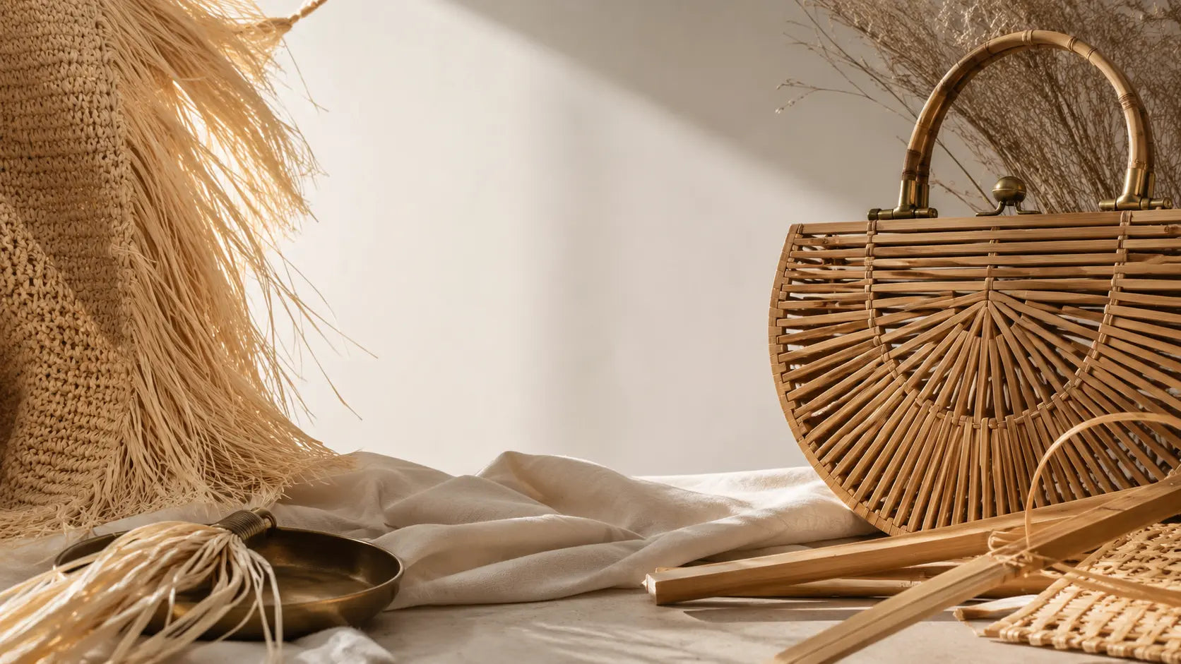 Raffia fibres and structured handwoven bamboo shown together as natural materials for luxury woven bags.