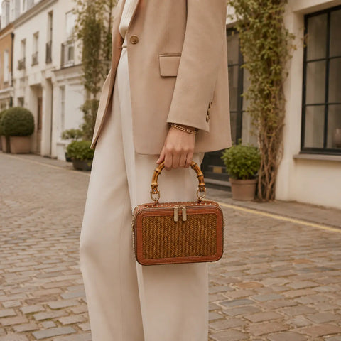 Model carrying the Regent Weave handwoven bamboo box bag with bamboo handle in an elegant street style look