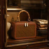Regent Weave handwoven bamboo handbag displayed in a refined London-inspired vintage window setting