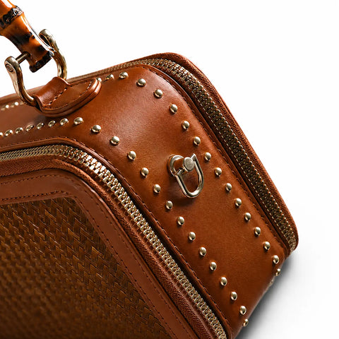 Side detail of the Regent Weave bamboo handbag with leather trim, metal studs and gold hardware
